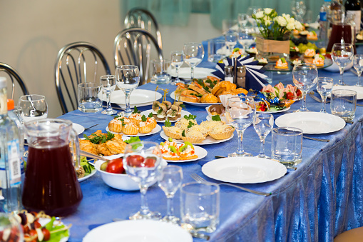 Served tables at the Banquet. Drink, alcohol, delicacies and snacks. Catering. A reception event.