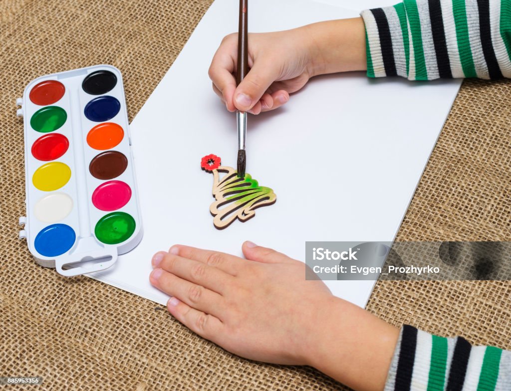 Die Hände des Kindes mit Pinsel malen einen Weihnachtsbaum mit Aquarellfarben. Lehren aus der Kreativität der Kinder. - Lizenzfrei Arm - Anatomiebegriff Stock-Foto