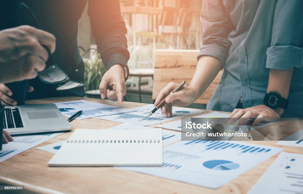 Bureau espace de coworking avec analyse de mise en marche du groupe au tableau de papier des données sur le bureau. - Photo de Conseil libre de droits