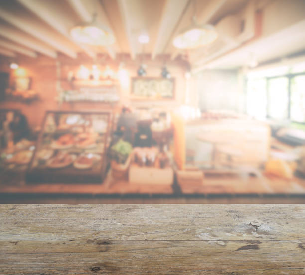 wooden table top with blur of coffee shop interior background stock photo