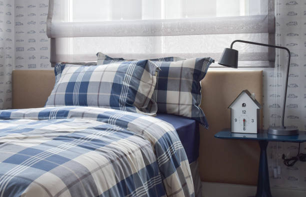 istock Cozy bedroom interior with pillows and reading lamp on bedside table 885968390