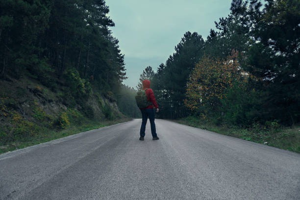 istock Man Waiting in Mountain Road 885970966