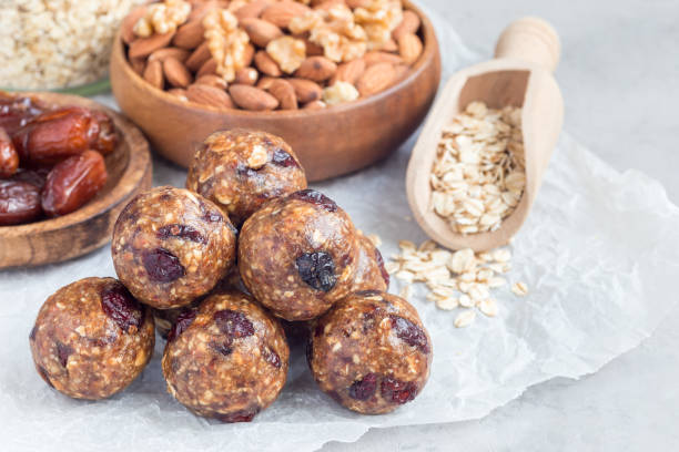 istock Healthy energy balls with cranberries, nuts, dates and rolled oats on parchment, horizontal, copy space 885973762