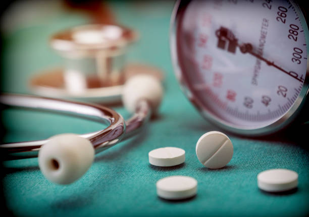 White pad next to a manometer to measure blood pressure and a stethoscope in a hospital, conceptual image White pad next to a manometer to measure blood pressure and a stethoscope in a hospital, conceptual image blood pressure medication stock pictures, royalty-free photos & images