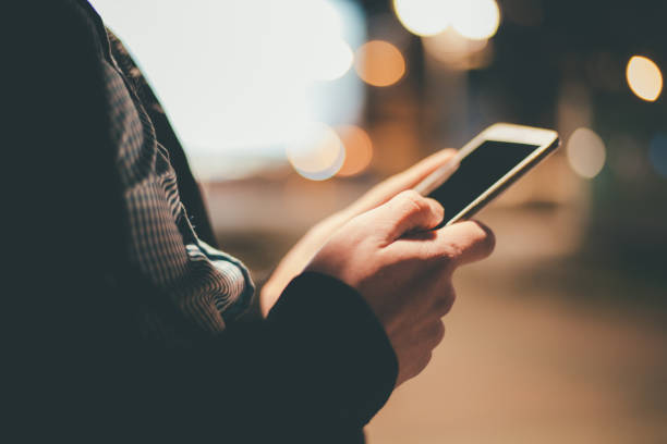 istock Using smart phone at night time outdoors 885977024