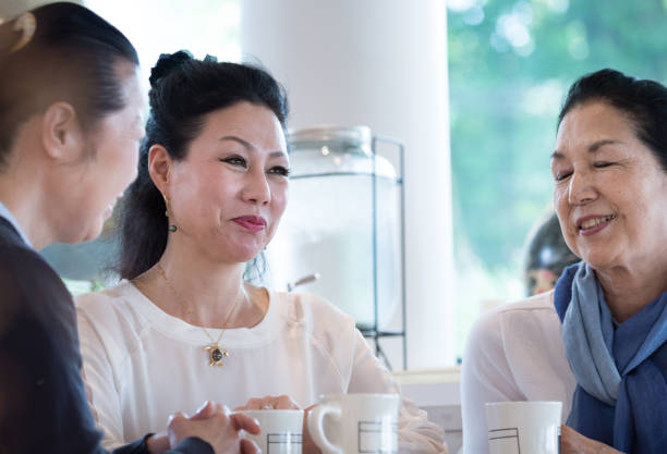 istock Three older Japanese women in cafe, seen through window 885983234