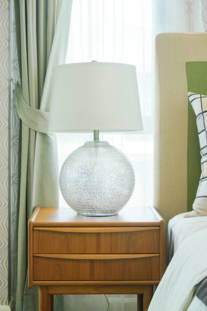 istock Reading lamp on wooden night table in bedroom 885986376