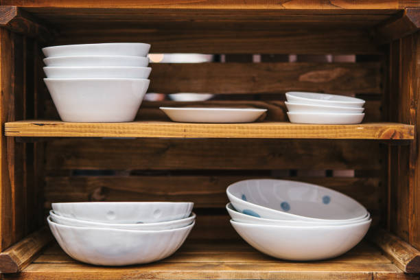 istock Many ordinary ceramic plates on wooden shelves. Kitchen accessories for cooking. 885986380