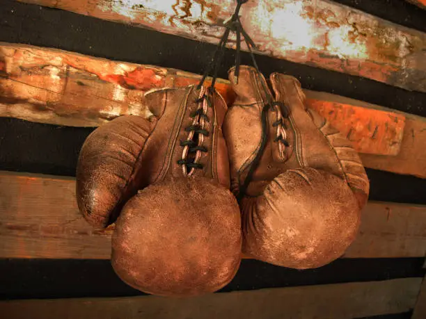 Photo of Boxing Gloves On The Wall. Old, Vintage Pair Of Leather Mittens