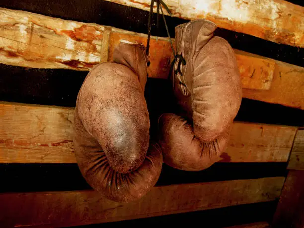 Photo of Boxing Gloves On The Wall. Old, Vintage Pair Of Leather Mittens