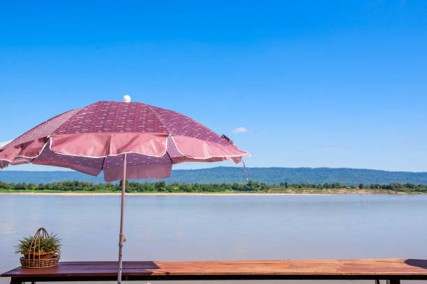 istock At river view in quiet summer blue sky, wind, sunshine and colorful umbrella 885992148