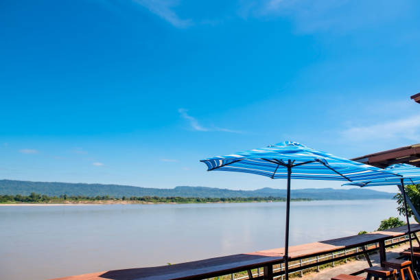 istock At river view in quiet summer blue sky, wind, sunshine and colorful umbrella 885992152
