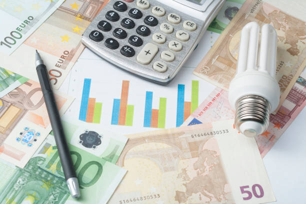 istock Energy saving lamp , chart and calculator on money background Energy saving,saving electricity concept. 886013458