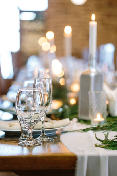 istock table setting, interior design, entertainment concept. on the blured background of fire lights there is transparen glasses of different shapes ans sizes designed for various drinks 886016174