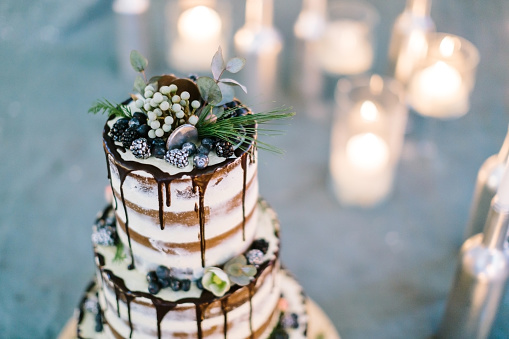 decoration, engagement, treatment concept. close up of top of delicious cake, cooked for celebrating wedding, amazingly decorated with floral elements, blackberries and frosting