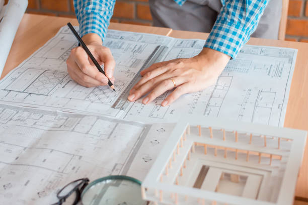 istock Concept architects,engineer holding pen pointing equipment architects On the desk with a blueprint in the office, Vintage, Sunset light.Selective Focus 886022322
