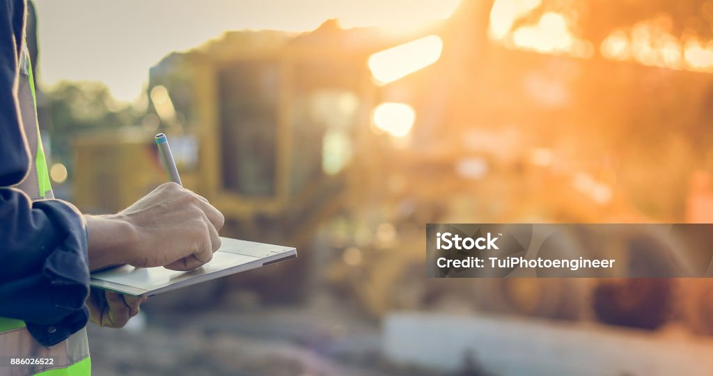 Ingeniero asiático con hardhat usando tableta pc inspeccionar y trabajando en obra - Foto de stock de Solar de construcción libre de derechos