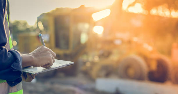 ingeniero asiático con hardhat usando tableta pc inspeccionar y trabajando en obra - maquinaria agrícola fotografías e imágenes de stock