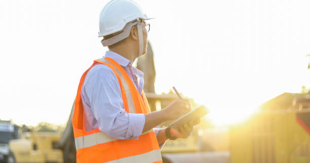 azjatycki inżynier z hardhat za pomocą komputera typu tablet kontroli komputera i pracy na placu budowy - crane mobile crane derrick crane construction vehicle zdjęcia i obrazy z banku zdjęć