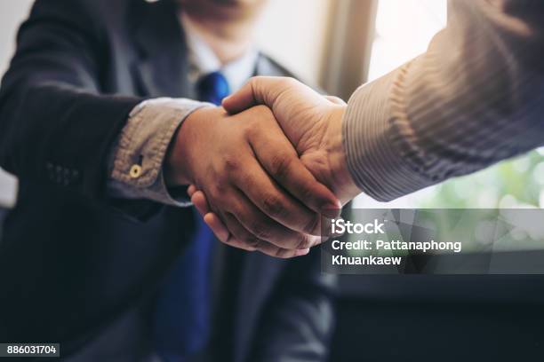 Foto de Dois Homens De Negócios Apertando As Mãos Durante Uma Reunião Para Assinar O Acordo E Se Tornar Um Parceiro De Negócios Empresas Empresas Confiantes Sucesso Lidando Contraem Entre Suas Empresas e mais fotos de stock de Dar as Mãos