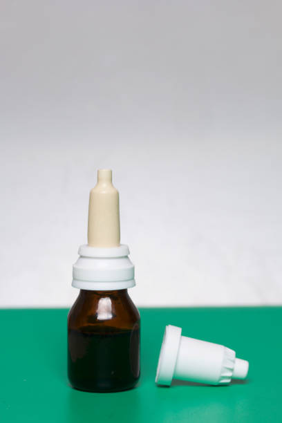 istock Nasal drops stand on the surface. On a surface of green color, on a white background. 886035534