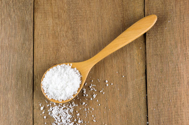 istock spoon full of salt  on wooden.top view 886038656