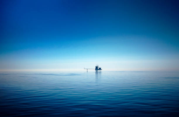 Drilling platform in the North Sea A North Sea drilling platform silhouetted against the horizon. calm before the storm photos stock pictures, royalty-free photos & images