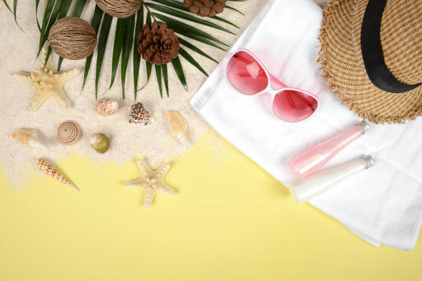 istock Summer concept and accessories(shells, starfish, coconut leaf)with sandy beach on yellow background. 886046484