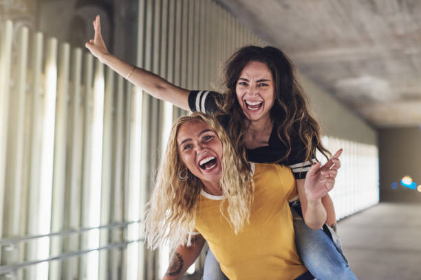 istock Two girlfriends having fun in the city at night 886057200