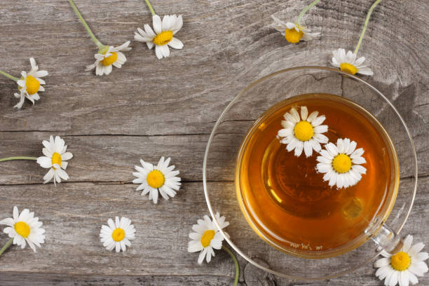 istock cup of green tea with chamomile on old wooden table. top view with copy space 886064710