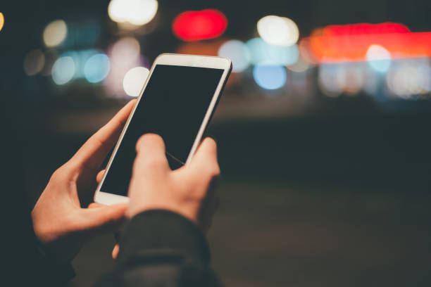 istock Using smart phone at night time outdoors 886075260