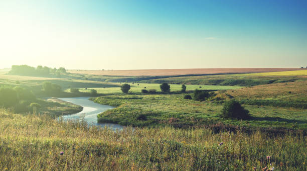 istock Sunny summer landscape wit river.Meadows and fields at sunrise.Beautiful view. 886084574
