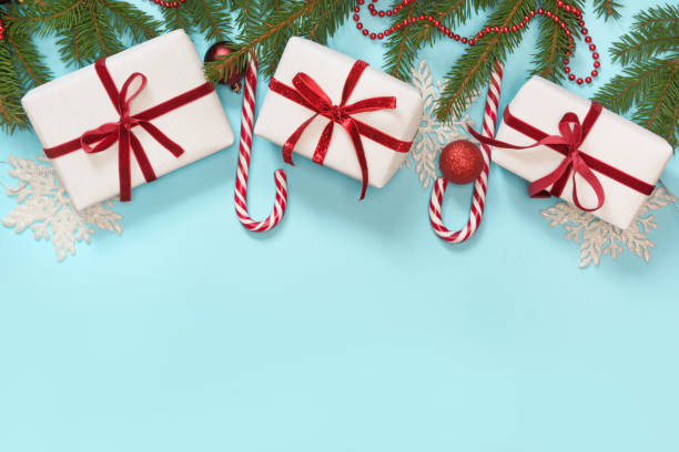 istock Christmas creative border with white and red decor, balls, gift, candy cane, snowflakes on blue background. Flat lay. Top view. Copy space. 886086852