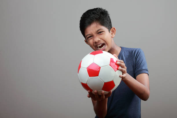 istock Cheerful young boy holds a ball in his hand 886092118