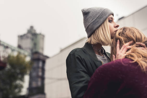 istock woman embracing her sitting boyfriend 886092614