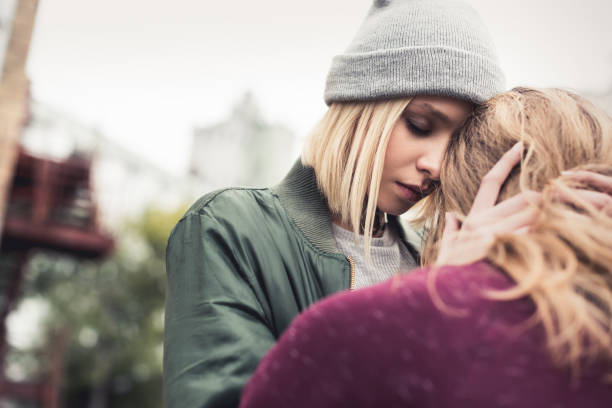 istock woman embracing her sitting boyfriend 886092720