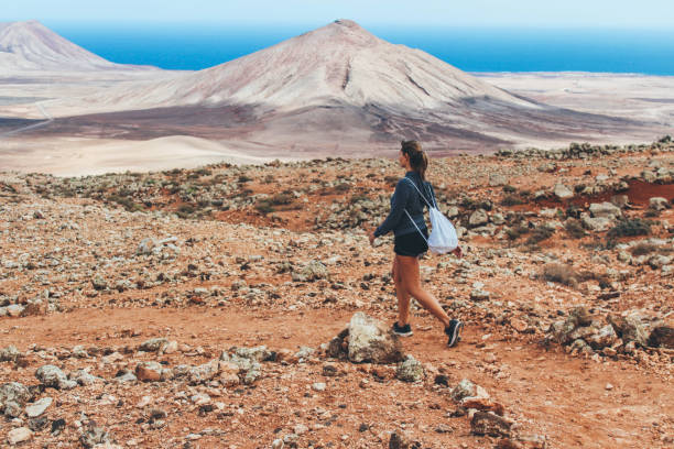 giovane donna che escursioni con vista panoramica sul vulcano - fuerteventura foto e immagini stock