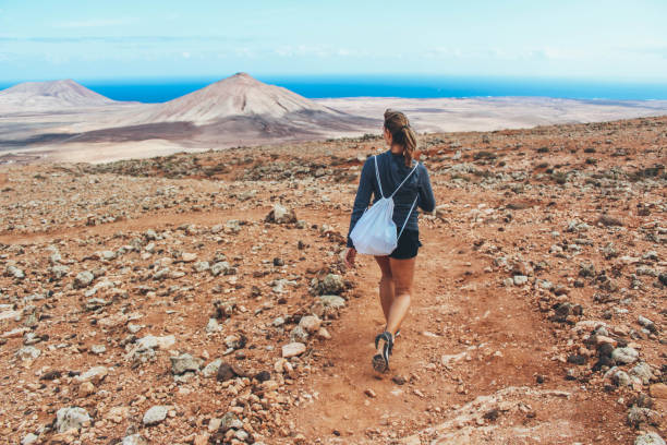 giovane donna che escursioni con vista panoramica sul vulcano - fuerteventura foto e immagini stock
