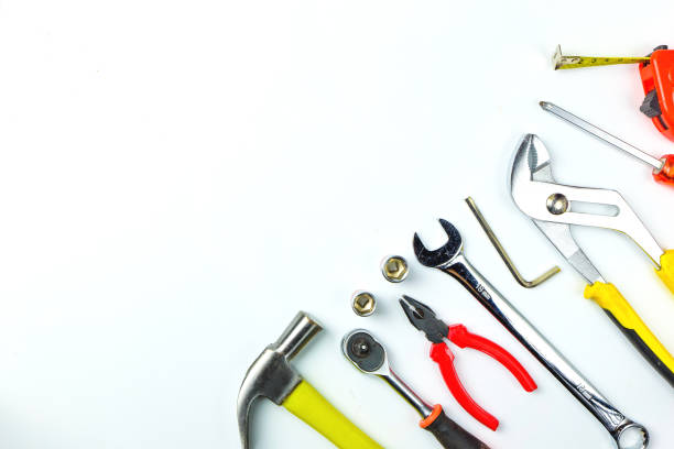 istock Top view of Working tools,wrench,socket wrench,hammer,screwdriver,plier,electric drill,tape measure,machinist square and safety glasses on white background.flat lay design for construction concept. 886124724
