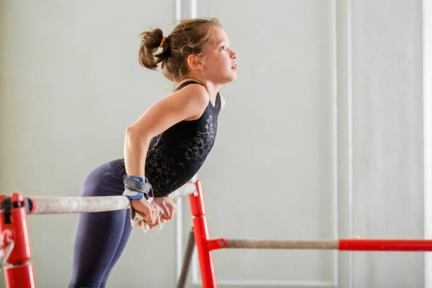 girl teenager doing sports girl teenager doing sports in the gym on the crossbar gymnastics stock pictures, royalty-free photos & images