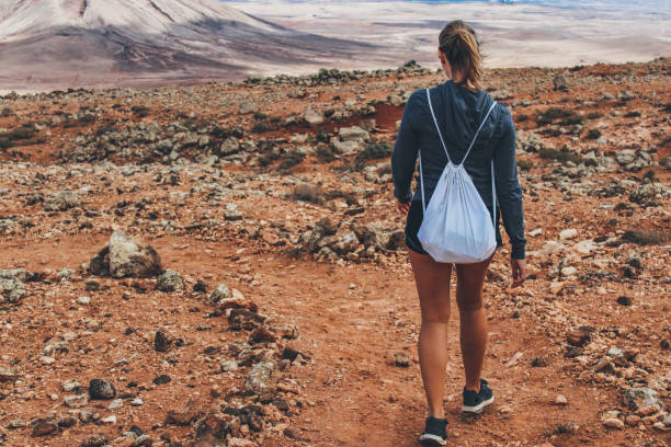 istock Young woman hiking with panoramic view on volcano 886134838