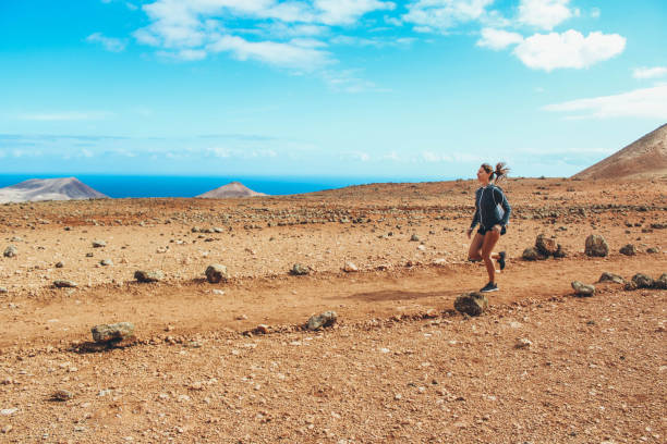 istock Young woman running on volcano 886135320