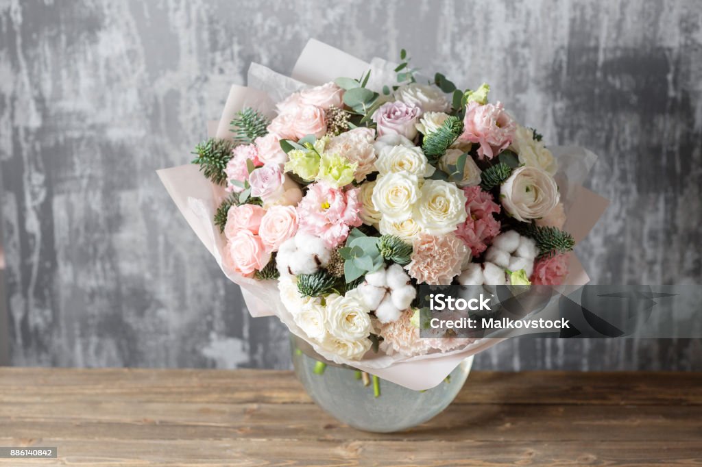 beau bouquet de fleurs mélangées dans un vase sur la table en bois. le travail du fleuriste à un magasin de fleurs - Photo de Fleur - Flore libre de droits