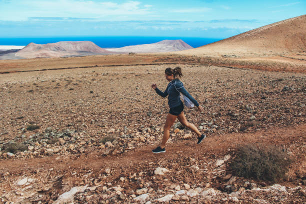 istock Young woman running on volcano 886151080