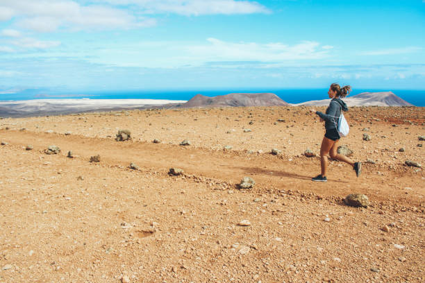 istock Young woman running on volcano 886155330
