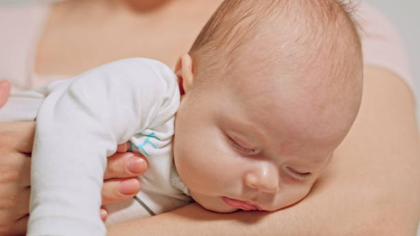 istock Baby in Mothers Arms Falling Asleep 886155938