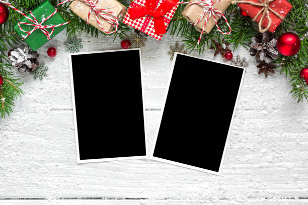 istock christmas blank photo frames with fir tree branches, decorations and gift boxes over white wooden background 886156160