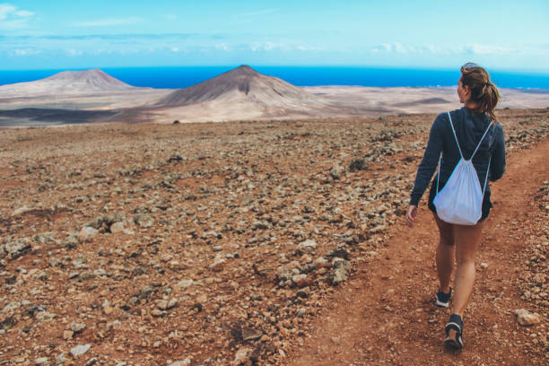 istock Young woman hiking with panoramic view on volcano 886157694