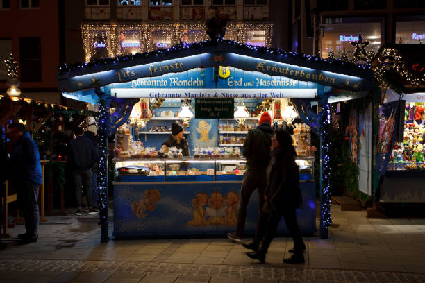 Tourists buying souvenirs at the market stall on the Christkindlmarkt at Marienplatz in Munich.