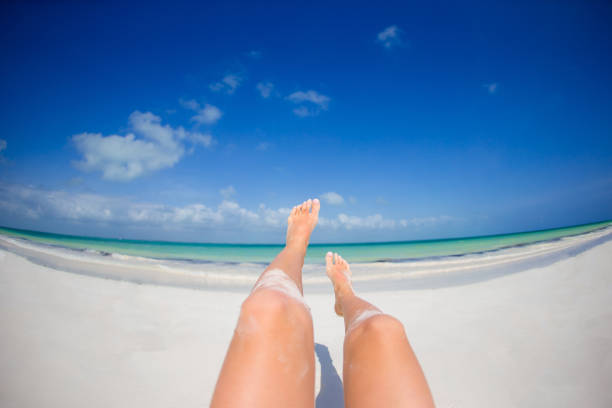 istock Female feet on white sandy beach. 886167858